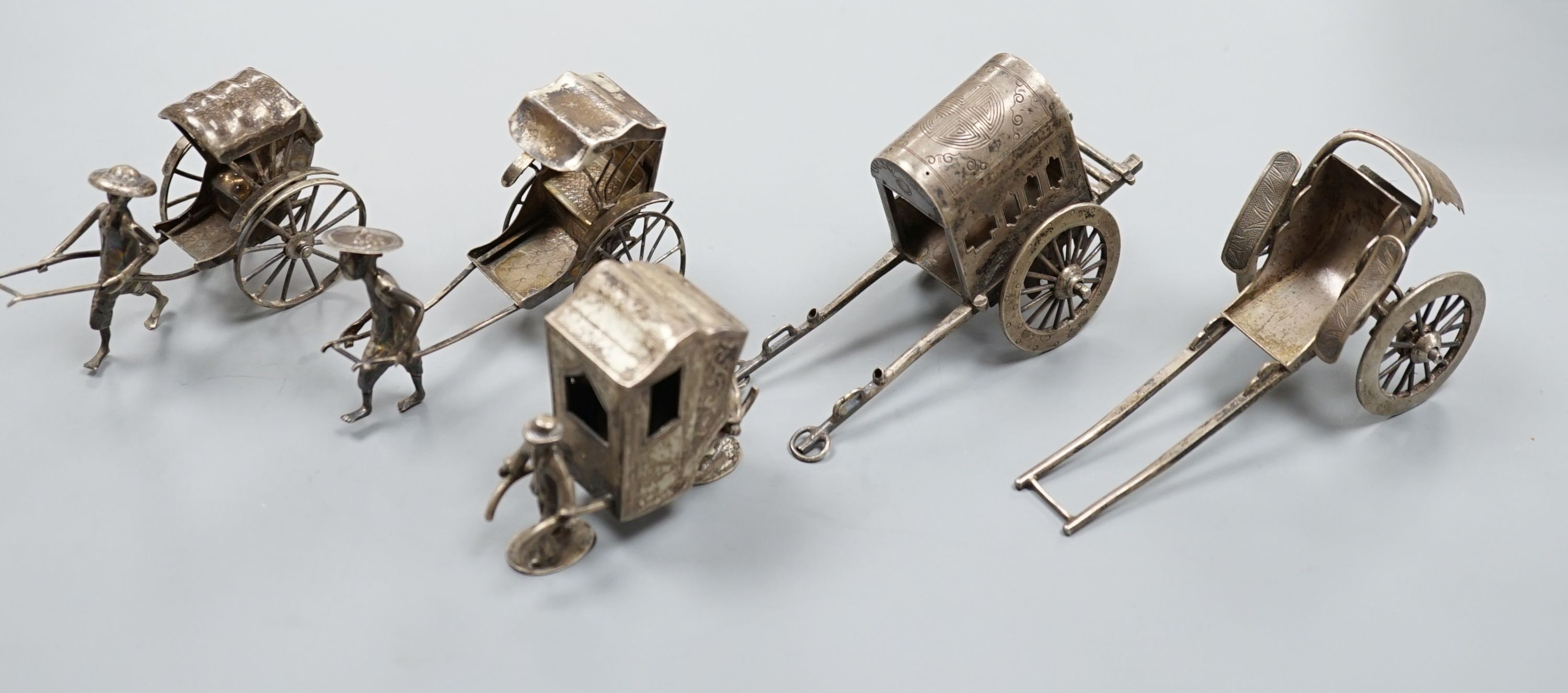 Two early 20th century miniature Chinese white metal models of a figure and rickshaw, by Wang Hing, length approx. 74mm. two other similar Chinese items and and unmarked miniature carriage.